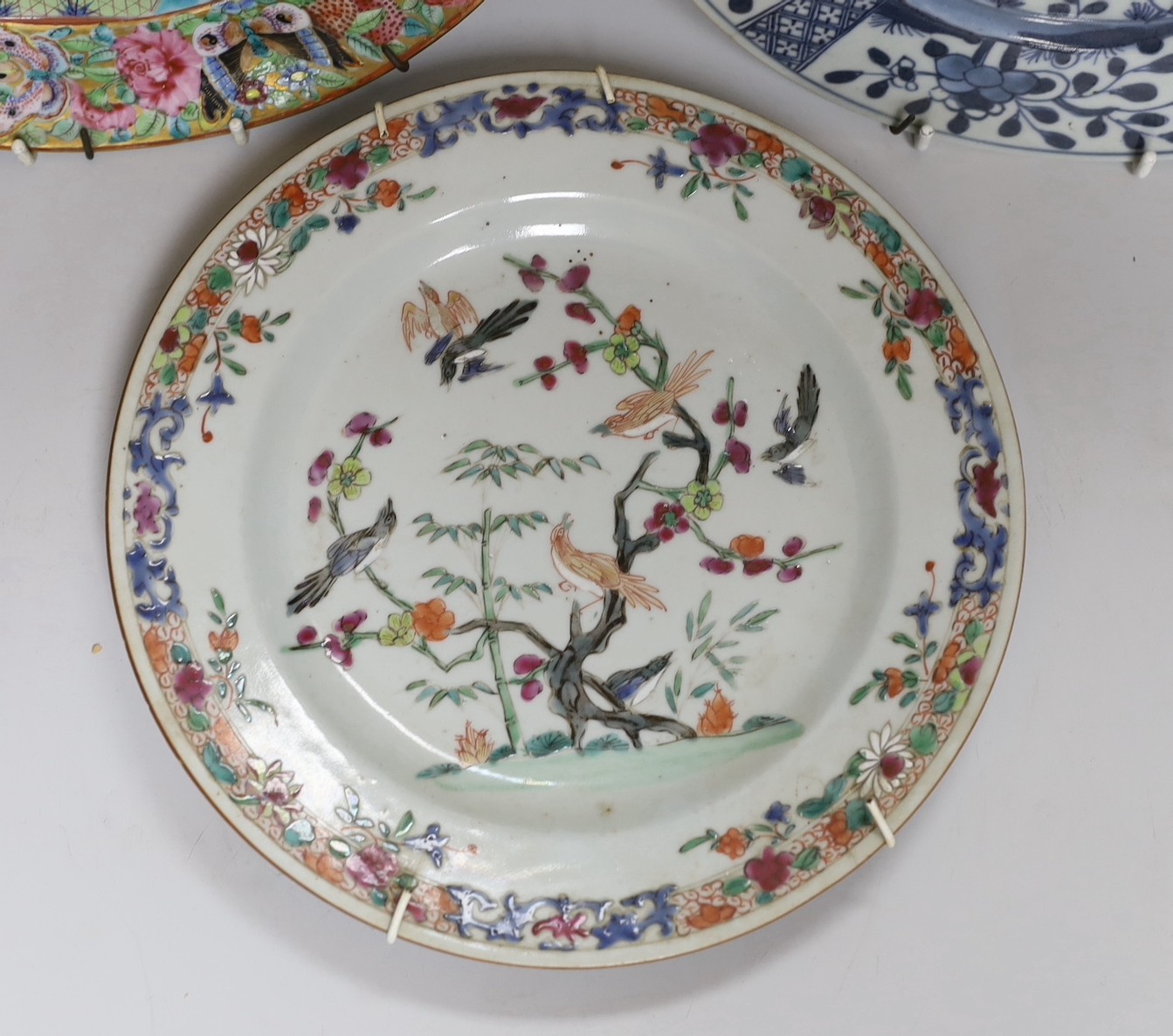 A 19th century Chinese enamelled porcelain dish, 25.4cm and two 18th century Chinese exports porcelain plates (3)